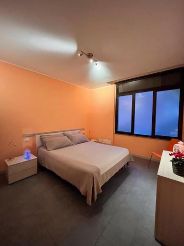 a bedroom with a large bed and two windows at El Jardin in Bellano