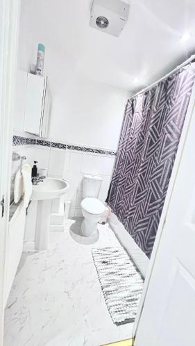 a bathroom with a toilet and a sink at Spacious 2-Bed Family Flat in Wimbledon Near Tube in London