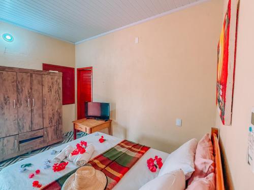 a bedroom with a bed and a table and a television at Pousada EcoVillage - Meu Xodó em Preá in Prea