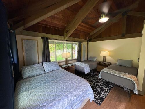 a bedroom with a large bed and a window at Kaena O Kekai in Hauula