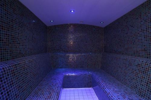 a blue room with a tub in a room with bricks at Park Hall Cottages ,Chorley, Preston,Lancashire in Chorley