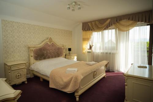 a bedroom with a large bed and a window at Vila Medana- Neamt in Humuleşti