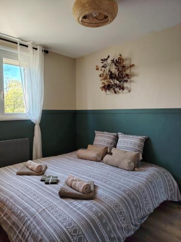 a bedroom with a large bed with towels on it at Une histoire à écrire in Belleville-sur-Saône