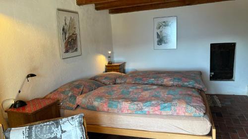 a bedroom with a bed and a table and a lamp at Rustico Bellavista in Mergoscia