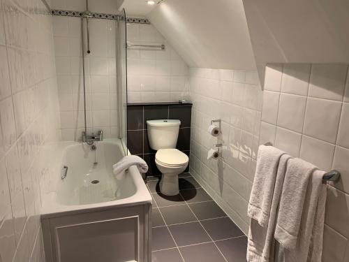 a white bathroom with a toilet and a sink at Barons Court Hotel Walsall in Walsall