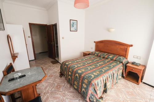 a hotel room with a bed and a table at Hotel Fnidaq in Fnidek