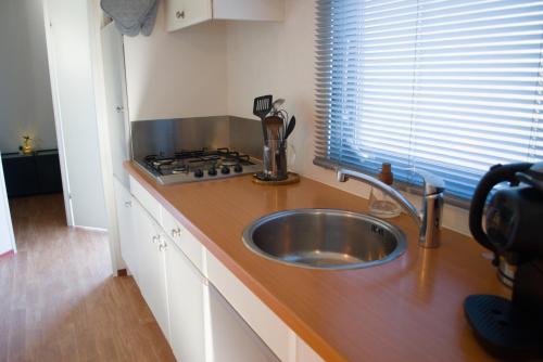 a kitchen counter with a sink and a stove at Huisje Weltevree Gendt in Gendt
