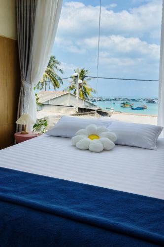 a bed with a teddy bear laying on it at Home Sake Hòn Sơn in Lai Sơn