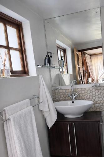 a bathroom with a sink and a mirror at Midrand Manor Guesthouse in Midrand