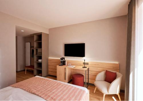 a bedroom with a bed and a desk and a tv at Hotel Adler Äpfingen in Äpfingen