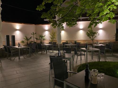 a restaurant with tables and chairs and lights at Hotel Adler Äpfingen in Äpfingen
