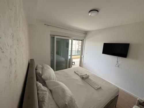a bedroom with a bed with a television on the wall at Apartment Lapis with pool near the beach- by TA Leut Agency in Privlaka