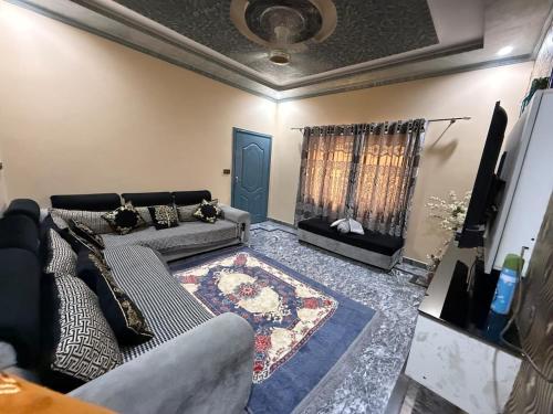 a living room with a couch and a rug at UK Guest House in Chāh Mahūnwāla
