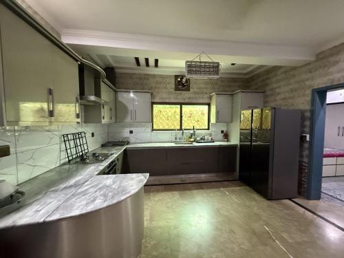 a large kitchen with a sink and a refrigerator at UK Guest House in Chāh Mahūnwāla