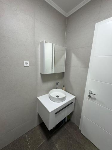 a bathroom with a white sink and a mirror at Apartment Lapis with pool near the beach- by TA Leut Agency in Privlaka