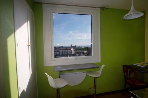 a green room with a window and two chairs at La chouette verte in Granville