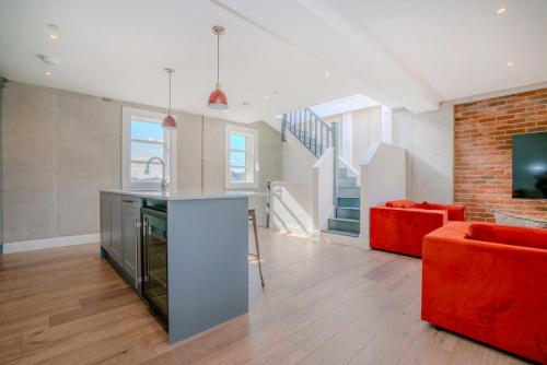 a kitchen and living room with a red couch at 3-Bedroom House in Wimbledon with Roof Terrace & Free Parking in London