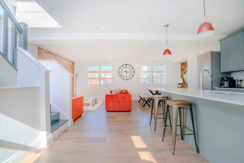 a kitchen with a counter and some bar stools at 3-Bedroom House in Wimbledon with Roof Terrace & Free Parking in London