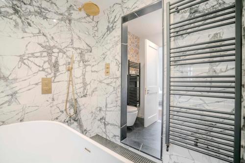 a bathroom with a large mirror and a tub at 3-Bedroom House in Wimbledon with Roof Terrace & Free Parking in London