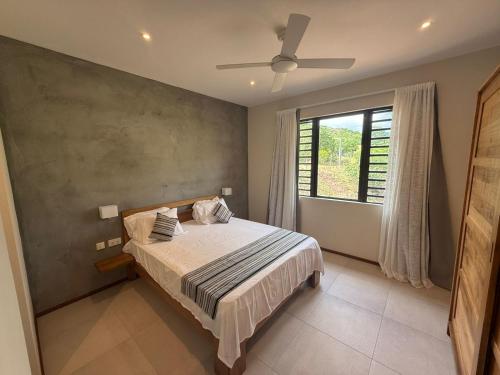 a bedroom with a bed with a ceiling fan at Casa Palmyre in Rivière Noire