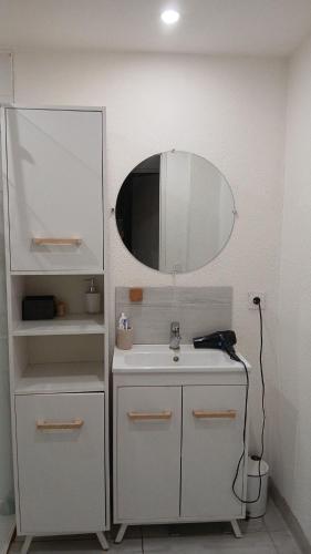 a white bathroom with a sink and a mirror at 2 Chambres, 4 personnes, jardin, proche centre ville in Perpignan