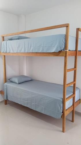 two bunk beds in a room with a ladder at OOK Home in Canoas de Punta Sal