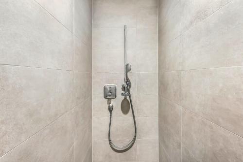 a shower with a shower head in a bathroom at Oskar25 Aparthotel in Ismaning