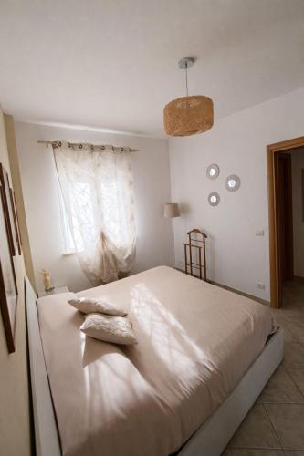 a bedroom with a large white bed with a window at Il Borghetto in Ciampino
