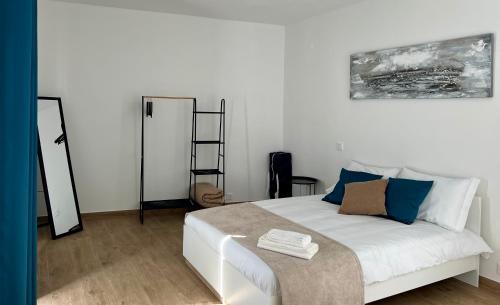 a bedroom with a white bed and a mirror at Ducal Guest House in Vila Viçosa