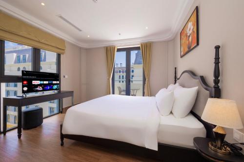 a bedroom with a white bed and a television at Grand Bay Hotel - Grand World Phu Quoc in Phú Quốc