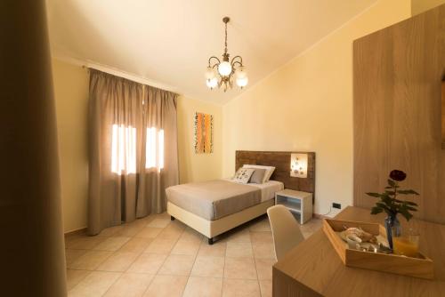 a bedroom with a bed and a table and a chandelier at BBuSS Country Club in Catanzaro