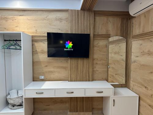 a room with a tv on a wooden wall at Flogeri in Vlorë