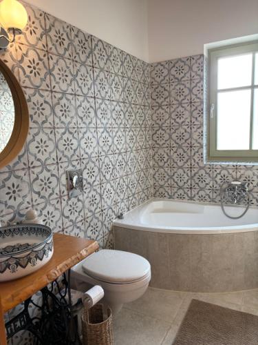 a bathroom with a tub and a toilet and a sink at Erdő mellett lebzselő in Mogyoróska