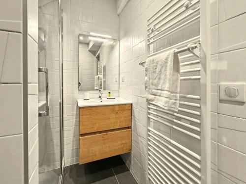 a white bathroom with a sink and a shower at Le Vercors in Valence