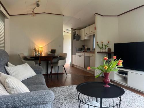 a living room with a vase of flowers on a table at Huisje Weltevree Gendt in Gendt