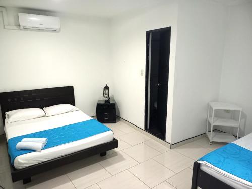 a bedroom with a bed with a blue blanket at Hotel Colombia - Apulo in Apulo