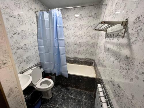 a bathroom with a toilet and a tub and a sink at Guest house Afsona old city in Bukhara