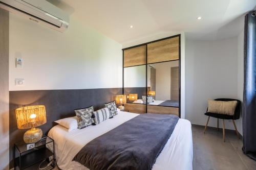 a bedroom with a large bed and a mirror at Casa u fornu Residence & Spa in LʼÎle-Rousse