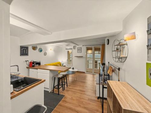 a kitchen and living room with a sink and a counter at Sous Les Toits in Valence