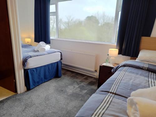 ein Schlafzimmer mit zwei Betten und einem Fenster in der Unterkunft Windsor Local in Haverfordwest