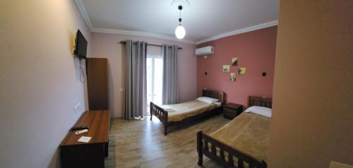 a hotel room with two beds and a table at JULI Veal in Tepelenë