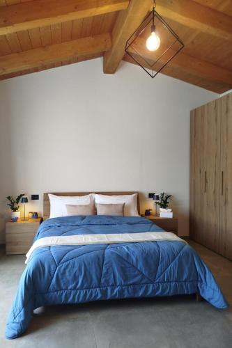 a bedroom with a blue bed and a wooden ceiling at Il Giardino di Sofia B&B in Piozzo