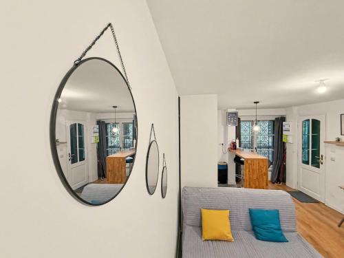 a mirror hanging on a wall in a living room at Le Refuge in Valence