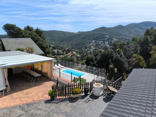 a house with a swimming pool and mountains in the background at Espacio Kybalion in Argentona