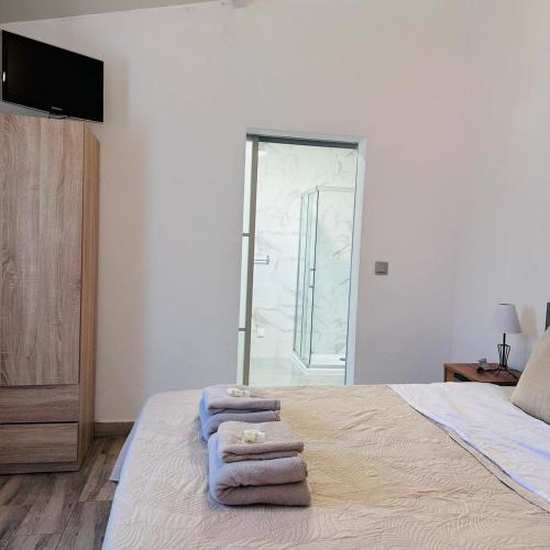 a bedroom with a bed with three towels on it at Vivenda Silva in Santo António da Charneca