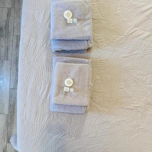 two towels sitting on top of a bed at Vivenda Silva in Santo António da Charneca