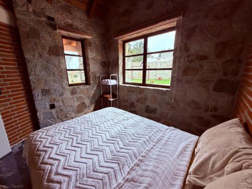 a bedroom with a bed in a room with two windows at Royal Fest By GEstores in Huasca de Ocampo