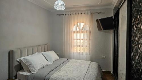 a bedroom with a bed with a television and a window at Guri Imperium in Krujë