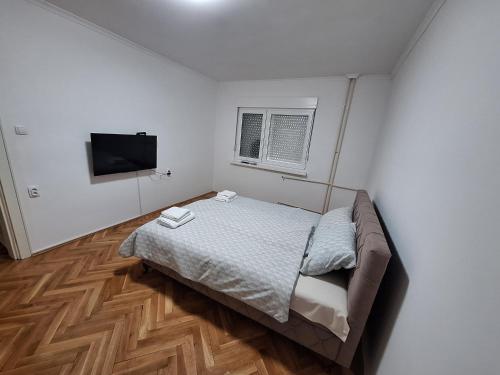 a bedroom with a bed and a flat screen tv at Rustic Elegance Suite in Vrbas