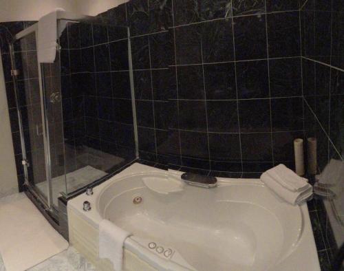 a white bath tub sitting next to a sink at Tally Ho Inn in Carmel